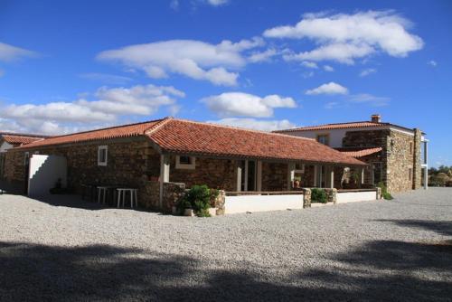a brick building with a table in front of it at Couto dos Pardinhos in Monforte da Beira