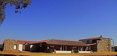 a large brick house in front of a house at Couto dos Pardinhos in Monforte da Beira