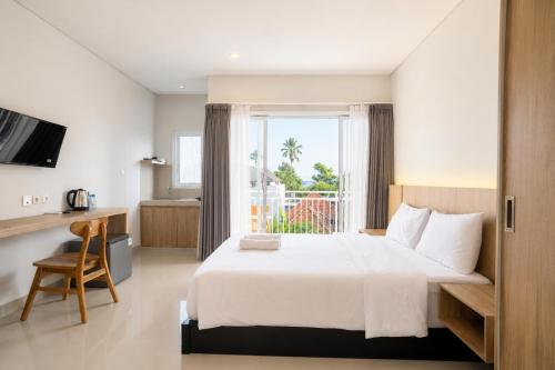 a bedroom with a large white bed and a window at Double A Cozy Living in Canggu