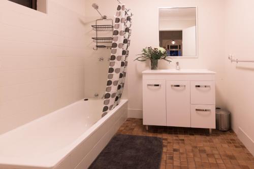 a bathroom with a tub and a sink and a mirror at The Stapleton in Kalgoorlie