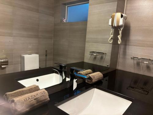 a bathroom with a sink and a phone on the wall at Mazarin Hiriketiya in Dickwella
