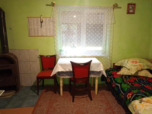 a table and chairs in a room with a window at Rustic House in Costeşti