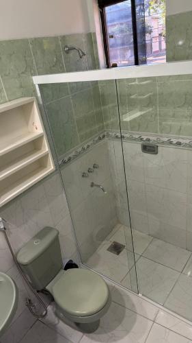 a bathroom with a toilet and a glass shower at Pousada Akros in Asunción