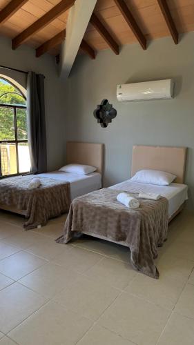 a bedroom with two beds and a large window at Pousada Akros in Asunción