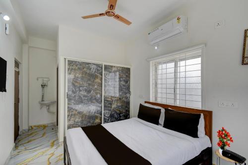 a bedroom with a bed and a window at Super Hotel O Gandimaisamma Thalli Temple Formerly GN Luxury Suits in Dhundgol