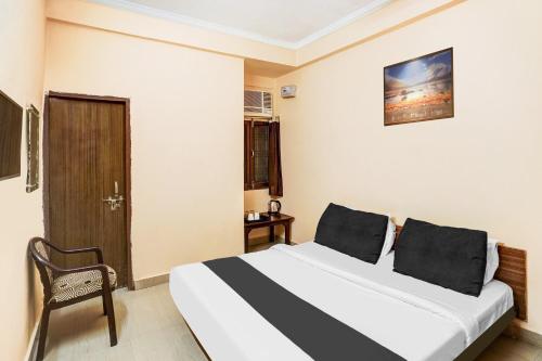 a hotel room with a bed and a chair at Hotel O Jankipuram Vikas Nagar in Lucknow