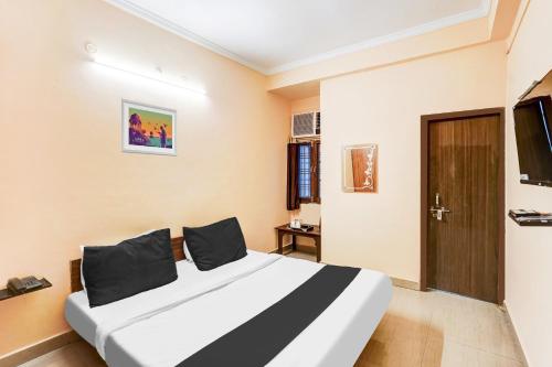a hotel room with a bed and a door at Hotel O Jankipuram Vikas Nagar in Lucknow