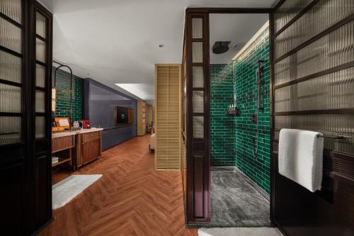 a bathroom with a shower with green glass at Hotel Indigo Harbin Central Avenue by IHG in Harbin