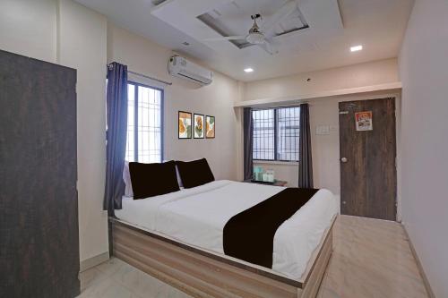 a bedroom with a large bed and two windows at Collection O Iskcon Aurangabad Formerly Everest Inn in Chikalthān