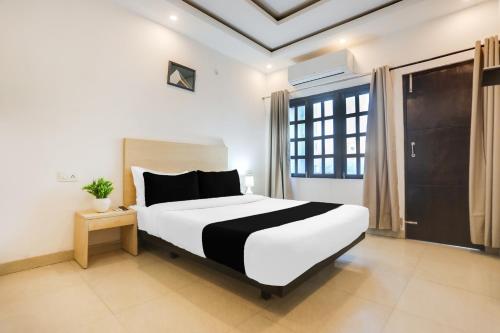 a bedroom with a large white bed and a window at Collection O Gol Park Atala in Prayagraj
