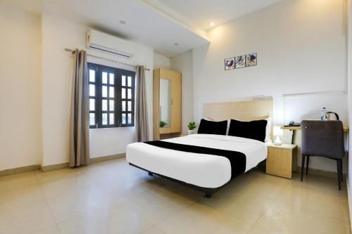 a bedroom with a bed and a desk and a window at Collection O Gol Park Atala in Prayagraj