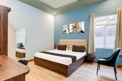 a bedroom with a bed and a table in a room at Super Hotel O Gomti Nagar Vigyan khand in Lucknow