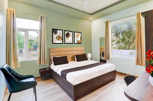a bedroom with a bed and a chair at Super Hotel O Gomti Nagar Vigyan khand in Lucknow