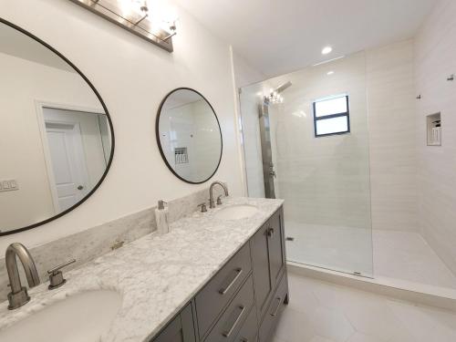 a bathroom with two sinks and a shower and a mirror at Zone T & A Escape in Fort Lauderdale