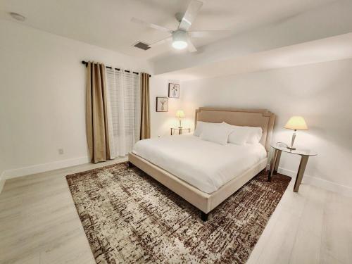 a white bedroom with a bed and a rug at Zone T & A Escape in Fort Lauderdale