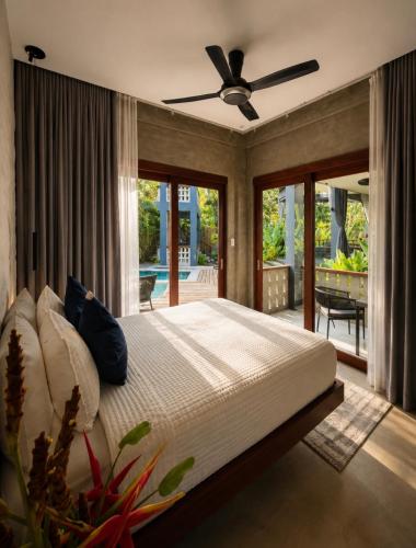 a bedroom with a bed with a ceiling fan at Islaya Siargao on Opening Phase in General Luna