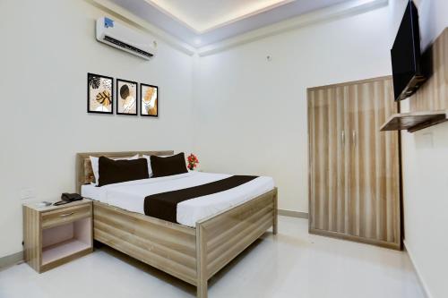 a bedroom with a bed and a flat screen tv at OYO Collection O Kalyanpur Metro Station in Kaliānpur