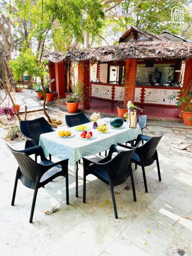 a table and chairs with food on it in front of a house at The Hideaway Hosur by evaddo stays in Hosūr