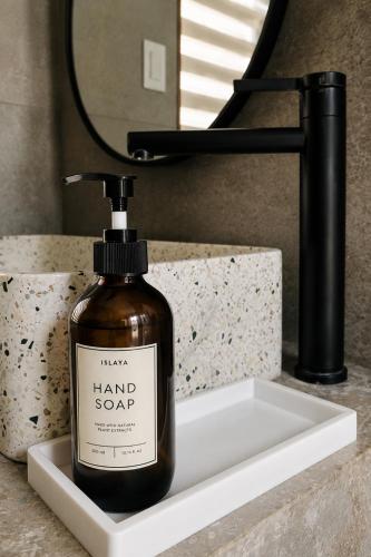 a bottle of hand soap sitting on a bathroom sink at Islaya Siargao on Opening Phase in General Luna
