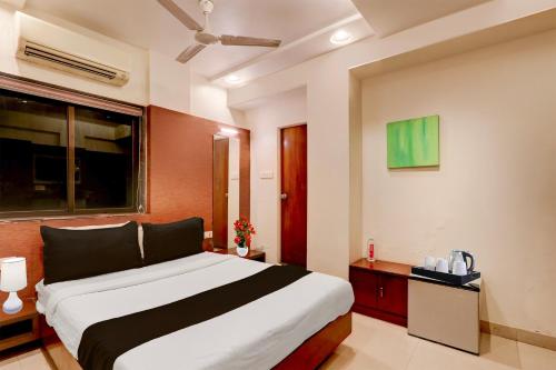 a bedroom with a large bed and a window at Townhouse Oak Ramdaspeth Downtown in Nagpur