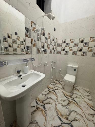 a bathroom with a sink and a toilet at nama villa in Arugam Bay