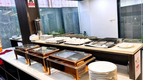 a kitchen with a counter with dishes on it at Hotel Takasi Heaven in Anakāpalle