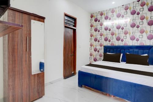 a bedroom with a blue bed and a wall at Super Hotel O by OYO ISBT Mohali Formerly Holiday Spot in Mohali