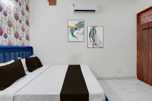 a bed in a room with two pictures on the wall at Super Hotel O by OYO ISBT Mohali Formerly Holiday Spot in Mohali
