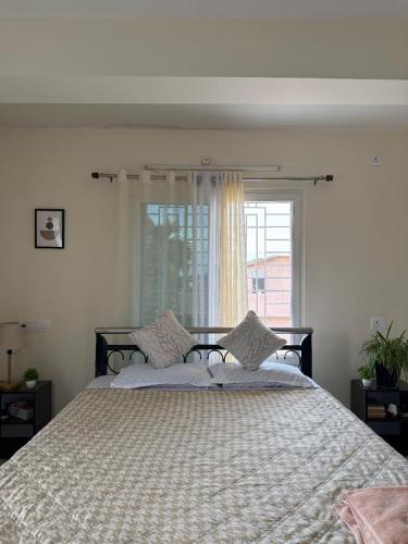 a bedroom with a large bed with a window at Retreat Homes in Siliguri