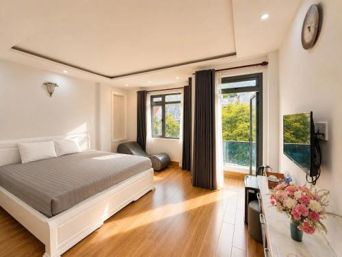 a bedroom with a bed and a television in it at The Land Hotel & Apartment in Vung Tau