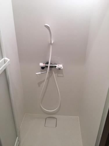 a shower in a bathroom with a hose on the wall at Fuji scenic house 73 in Fujikawaguchiko