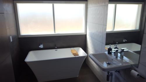 a bathroom with a white tub and a sink at Lara Lodge in Lara