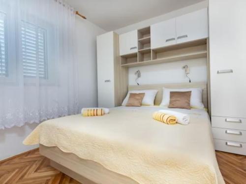 a bedroom with a large white bed with yellow pillows at Vacation home Marin in Vinišće