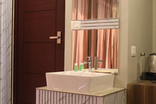 a bathroom with a white sink and a mirror at Grand Heritage in Ernakulam