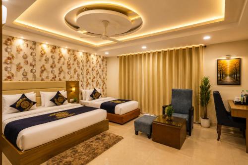 a hotel room with two beds and a desk at HOTEL D'CAPITOL - DELHI AiRPORT in New Delhi