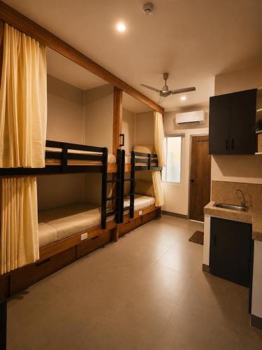 a room with two bunk beds and a kitchen at Casa Andrea Bukidnon in Impasugong