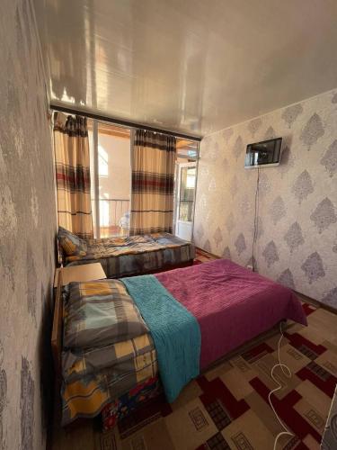 ein Schlafzimmer mit einem großen Bett in einem Zimmer in der Unterkunft Baisuu in Bosteri