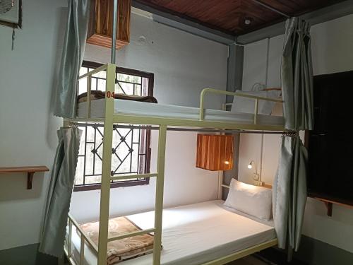 a room with two bunk beds and a window at City Backpackers Hostel in Luang Prabang