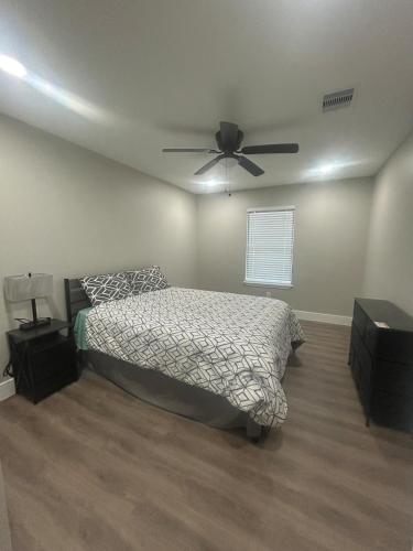 a bedroom with a bed and a ceiling fan at Only minutes away from Surfside Beach in Freeport