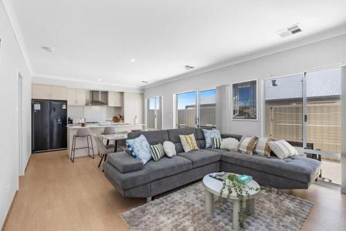 a living room with a couch and a kitchen at Alkimos Coastal Escape in Alkimos