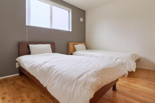 two beds in a room with a window at Ｔｉｌｔ - Vacation STAY 16720 in Karatsu