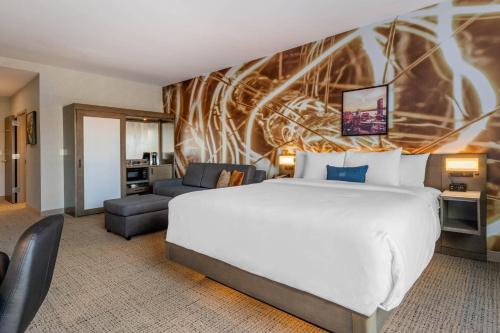 a hotel room with a large bed and a couch at Cambria Hotel West Orange in West Orange