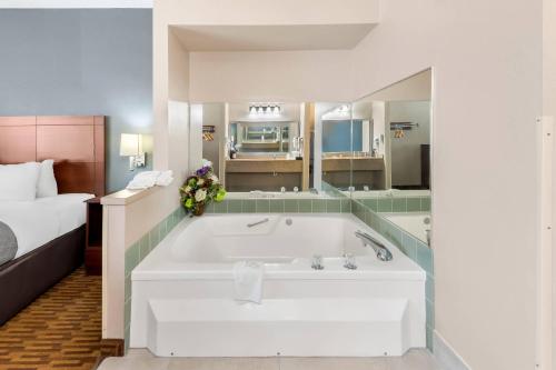 a large bath tub in a room with a bed at Quality Inn & Suites Lawrence - University Area in Lawrence