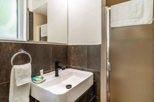 a bathroom with a white sink and a mirror at La Luna Inn, an Ascend Collection Hotel in San Francisco