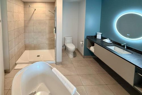 a bathroom with a tub and a toilet and a sink at Quality Inn & Suites Temiscouata-sur-le-Lac in Notre-Dame-du-Lac