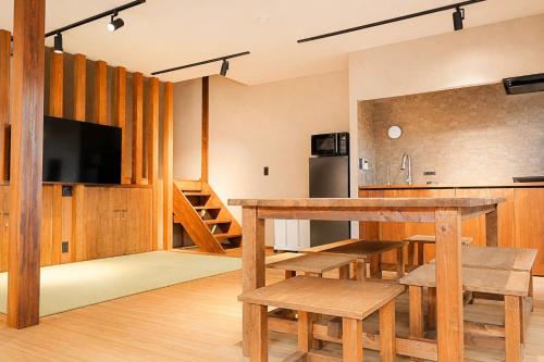 a kitchen and dining room with a wooden table and chairs at ceueu 櫟本駅 in Tenri