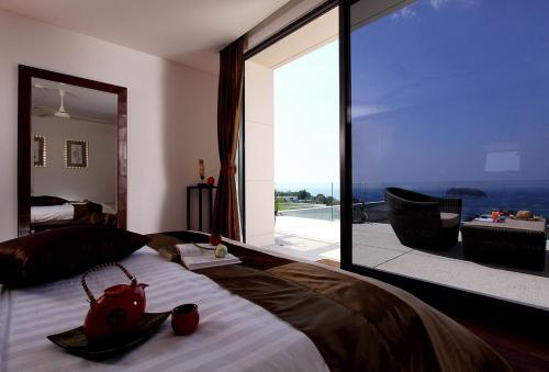 a bedroom with a large bed with a large window at The heights luxury sea view 2BR near Kata Beach in Kata Beach