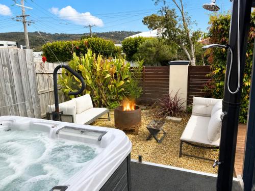 a hot tub in a yard with two chairs at Solander in Dromana with Private Spa by Ready Set Stay in Dromana