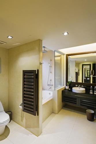 a bathroom with a toilet and a sink and a tub at Impiana Beachfront Resort Patong, Phuket in Patong Beach