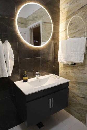 a bathroom with a sink and a mirror at Otopeni Garden Hotel in Otopeni
